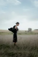 Pollera midi de eco cuero color beige, de corte recto y tiro alto, con costuras verticales decorativas y detalle de cinturón fino con flecos.