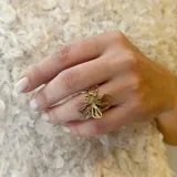 Anillo de bronce color dorado con forma de panal de abeja y una abeja en el centro.