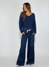 Pantalón de jean de tiro alto, corte palazzo y pierna ancha, color azul oscuro.