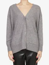 Cardigan de punto gris con escote en V, cierre frontal con broches ocultos y dos bolsillos frontales aplicados. Presenta puños y ruedo acanalados.