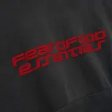 Hoodie de corte oversize en color gris oscuro, con capucha y bolsillo frontal tipo canguro. Presenta un estampado gráfico en color rojo en el pecho con la inscripción Fear of God Essentials.