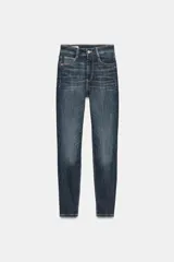 Jeans skinny de tiro alto y largo al tobillo, confeccionados en tejido super elástico con diseño de cinco bolsillos, cierre frontal con cremallera y botón metálico.
