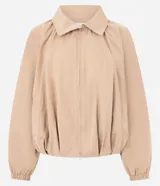 Campera bomber de sarga color beige, con diseño cortavientos, cuello alto con botones a presión y cierre frontal. Presenta mangas largas con puños elastizados, pliegues delanteros que aportan volumen y ruedo con elástico. Marca Renner.