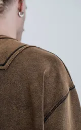 Buzo de cuello redondo con calce oversize y hombros caídos. Confeccionado en algodón gamuzado pesado con un proceso de lavado efecto óxido que genera un tono irregular. Presenta costuras expuestas a contratono y detalles de roturas en cuello, puños y ruedo, logrando una estética desgastada.