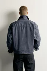 Sobrecamisa de corte relaxed fit confeccionada en tejido de mezcla de lyocell y algodón, en color azul oscuro con efecto lavado. Presenta cuello camisero, manga larga con puños abotonados, bolsillos frontales de vivo y cierre central de botonadura.