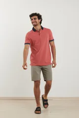 Remera tipo polo de manga corta, color azul marino jaspeado, con cuello y ribetes en las mangas de color azul oscuro y blanco.