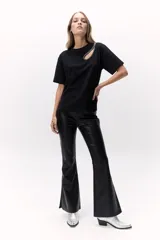 Remera negra de algodón con cuello redondo y manga corta. Presenta un calado en el hombro con detalle de pedrería.