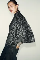 Jersey de punto con estampado animal jacquard en tonos gris y negro, caracterizado por su cuello subido y mangas anchas de corte holgado.