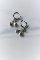 Aros de acero quirúrgico hipoalergénico, con argolla pequeña y dije colgante en forma de cerezas.
