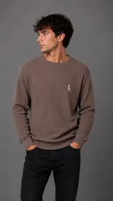 Buzo de punto con textura waffle, color marrón, de cuello redondo y manga larga con puños acanalados.