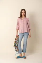 Camisa de lino color rosado, de corte holgado y cuello mao, con mangas 3/4 y cierre frontal con botones. 