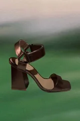 Sandalia de tacón alto cuadrado, color bronce metalizado, con tira frontal ancha y pulsera ajustable al tobillo con cierre de hebilla.