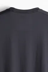Remera deportiva gris oscuro de corte recto, cuello redondo y mangas cortas. Confeccionada en tejido funcional DryMove™ que ayuda a absorber el sudor.