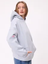 Canguro color crema con capucha y estampado grande en la espalda de un sol con un ojo, montañas, mariposas y texto.