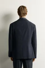 Blazer de corte relaxed fit con cuello de solapas de muesca y cierre frontal de un botón. Cuenta con bolsillos de plastrón en la cadera y mangas largas.