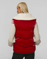 Chaleco puffer rojo con cuello de sherpa color crema, cierre frontal con cremallera y bolsillos laterales.