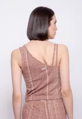 Top asimétrico de tejido de punto color ladrillo con diseño de líneas verticales en azul. Tiene cuello a la base y breteles finos en un hombro.