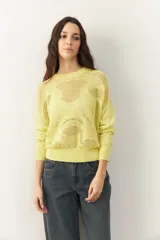 Sweater amarillo calado de manga larga con cuello redondo, puños y cintura elastizados.