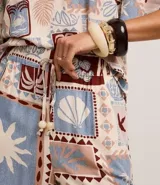 Short de cintura alta confeccionado en viscosa estampada con motivos tropicales. Tiene elástico y lazo en la cintura.