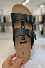 Sandalia marrón con diseño de dos tiras ajustables con hebillas metálicas y plantilla anatómica.