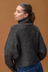 Sweater de cuello alto confeccionado en tejido de punto con sutiles destellos de lurex. Presenta mangas largas con puños ajustados y un calce holgado y cómodo.
