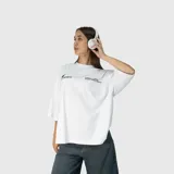 Remera de corte oversize color blanco, con mangas cortas y cuello redondo. Presenta un estampado gráfico minimalista en color negro en el pecho.