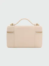Cartera tipo vanity bag de Marc Jacobs, color beige, con cierre superior, asa corta superior y correa larga ajustable y extraíble. Presenta logo metálico dorado en el frente.