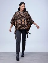 Poncho tejido con diseño tribal en blanco y negro, terminación con borlas.