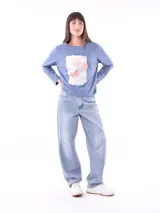 Remera de manga larga color azul, con cuello redondo y un estampado central de flores en tonos pastel sobre un recuadro gris claro.