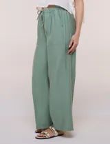 Pantalón holgado de tiro alto, color verde, con bolsillos frontales aplicados y cordón ajustable en la cintura.