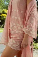 Conjunto de pijama compuesto por una musculosa de escote redondo y un short con elástico en la cintura. Ambas piezas están confeccionadas en tela a rayas finas con detalles bordados florales y terminaciones con puntilla festoneada.