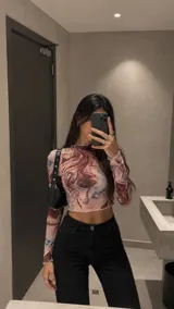 Top de microtul de manga larga con estampado marmolado en tonos marrones y rojizos. Presenta cuello redondo y terminaciones con borde ondulado.