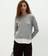 Suéter de punto gris con cuello redondo y mangas largas, que incorpora un diseño de camisa blanca integrada en el ruedo, creando un efecto de capas.
