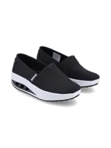 Zapatilla slip on Hush Puppies modelo Angelo, color negro, con capellada de lona canvas, inserción elástica en el empeine y suela alta con cámara de aire y aberturas laterales.