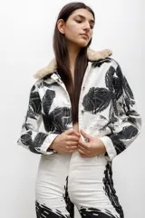 Chaqueta de denim de algodón con estampado gráfico en blanco y negro, cuello con detalle de piel sintética y cierre frontal con botones.