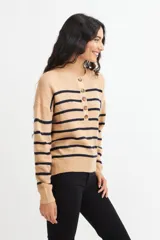 Sweater de punto color crema con rayas horizontales azul marino, cuello redondo y media botonadura frontal con botones marrones.