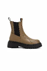 Bota tipo Chelsea de caña media, color tostado, con paneles laterales elásticos en color negro y suela track dentada de goma negra.
