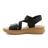 Sandalia de mujer color crema, con tira ancha sobre los dedos, tira cruzada sobre el empeine, pulsera con velcro al tobillo y plataforma baja.