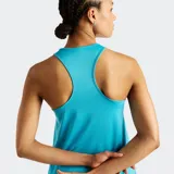 Musculosa deportiva New Balance Sport Essentials color celeste, de cuello redondo, sin mangas con sisas amplias y dobladillo trasero más largo. Incluye logotipo reflectante en el pecho.