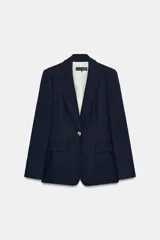Blazer de cuello solapa y manga larga con cierre frontal de un botón. Presenta bolsillos delanteros con solapa y diseño estructurado.