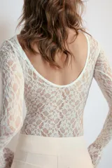 Body de encaje color marrón, con cuello redondo, manga larga y espalda descubierta.