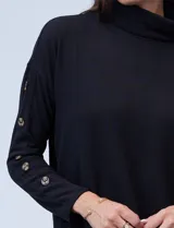Polera negra de tejido soft con cuello alto y mangas largas con aplique de botones.