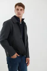 Sobretodo estilo Harrington de color gris oscuro, con cuello camisero, cierre frontal con botones y bolsillos laterales. Presenta un diseño clásico y estructurado.
