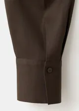 Camisa de lyocell color marrón oscuro, de manga larga y diseño fluido con cuello camisero y cierre frontal abotonado.