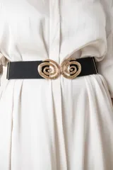 Cinturón elástico negro con hebilla metálica dorada formando dos espirales.