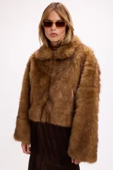 Campera crop de pelo sintético color caramelo, con cierre frontal y diseño de volumen protagonista.