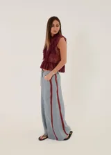 Pantalón de lino color celeste grisáceo, de corte ancho y talle medio, con detalles en bordó y costuras pespunteadas.