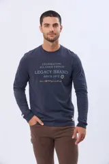Remera de algodón de manga larga color azul marino, con cuello redondo y estampado frontal en tonos celestes y dorados que dice "Celebrating All Good Things Legacy Brand Since 1972" y "Live a life that you would relive".