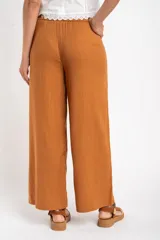 Pantalón de lino color tostado, de corte recto y tiro medio.