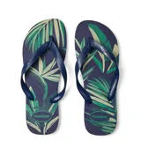 Sandalias tipo ojotas Havaianas con estampado de hojas tropicales en tonos verdes sobre base azul marino. Presentan tiras de goma en color azul marino con el logo de la marca en relieve.